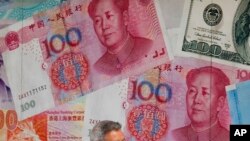 一百元面值的人民幣和美元。（美聯社示意圖）