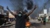An opposition supporter reacts in front of a burning barricade during demonstrations called by the opposition parties in Dakar on Feb. 4, 2024. 
