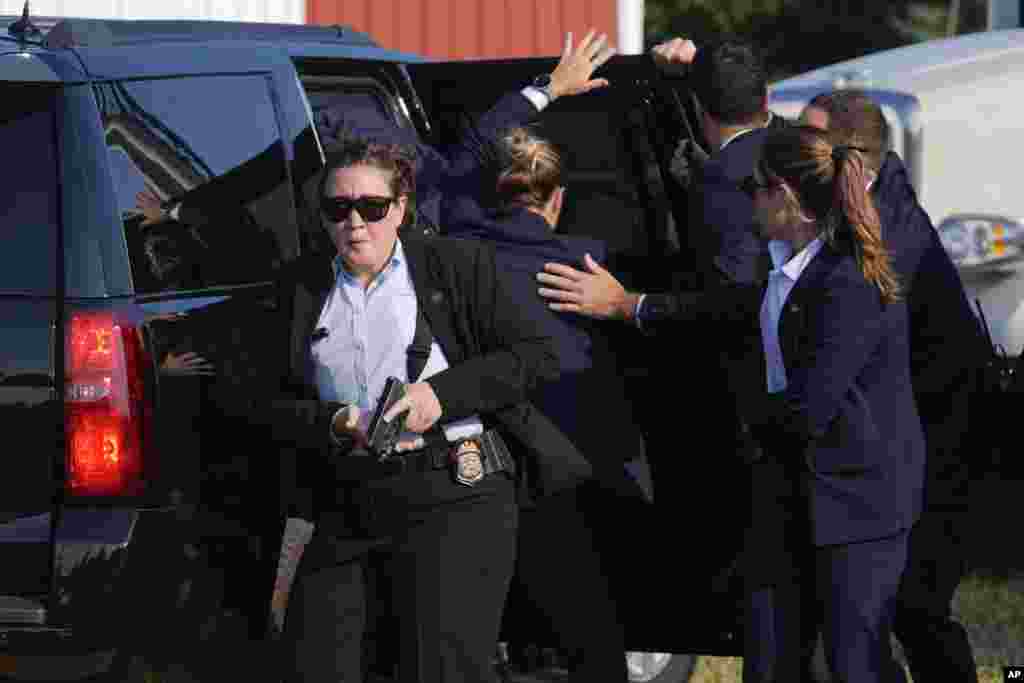 Donald Trump est entouré d'agents des services secrets alors qu'il est emmené dans un véhicule.