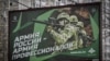 FILE - A photograph taken Oct. 24, 2022, shows a recruitment poster displaying Russian soldiers with a slogan reading 'Army of Russia - Army of professionals' as seen on a street in Moscow. 