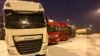FILE - Ukrainian truck drivers wait to cross from Poland back into Ukraine in Korczowa, Poland, on Dec. 7, 2023. 