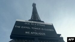 A board informs visitors that the site is closed after staff went on strike, at the bottom of the Eiffel Tower in Paris, Dec. 27, 2023.