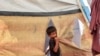 A boy stands outside a tent at a camp for people displaced by conflict in Khan Yunis in the southern Gaza Strip on July 11, 2024, amid the ongoing conflict in the Palestinian territory between Israel and Hamas.