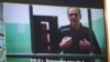 FILE - A screen shows jailed Kremlin critic Alexei Navalny as he arrives to listen to a hearing on an appeal lodged against a court decision to jail him for 19 years in a maximum security prison on extremism-linked charges, at a court in Moscow, Russia, Sept. 26, 2023.