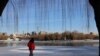 FILE - A man walks by a frozen lake at a park during winter solstice in Beijing, China Dec. 22, 2023.