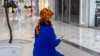 A Turkmen woman wearing a traditional dress reads news on her smartphone in Ashgabat, Turkmenistan, Jan. 31, 2024. 