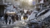 Palestinians displaced by the Israeli air and ground offensive on the Gaza Strip walk through a dark streak of sewage flowing into the streets of the southern town of Khan Younis, Gaza Strip, July 4, 2024.