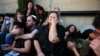 FILE - Friends and family take cover as rocket sirens sound during the funeral of Sagiv Ben Zvi, 24, who was killed following the deadly infiltration by Hamas gunmen from the Gaza Strip, in Holon, Israel, Oct. 26, 2023.