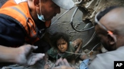 Palestinezët përpiqen të nxjerrin një vajzë nga rrënojat e një ndërtese pas sulmeve izraelite në kampin e refugjatëve në Jabalia, në veri tëp Rripit të Gazës. 1 nëntor 2023.
