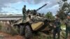 In this photo provided by the Kokang online media, members of an ethnic armed forces group known as the Three Brotherhood Alliance, check an army armored vehicle the group allegedly seized from Myanmar's army outpost on a hill in Hsenwi township in Shan state, Nov. 24, 2023.