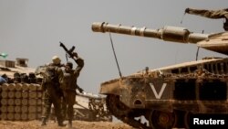 以色列士兵在以色列-加沙邊境附近的坦克和彈藥堆附近。 (2024年5月9日)