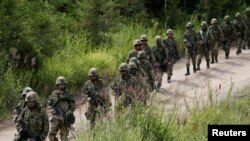 FILE - Japan Ground Self Defense Force members take part in a joint exercise with U.S. Marines on the northern island of Hokkaido, Japan, Aug. 16, 2017. Japan plans to hold joint military exercises with Germany and Spain on the island in June 2024.