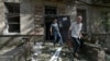 Local residents leave a destroyed residential building after a missile attack in Lugansk, Russian-controlled Ukraine, June 7, 2024.
