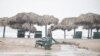 Furniture strewn along Miramar Beach by the winds of Tropical Storm Alberto is recovered, June 20, 2024. The storm weakened Thursday as it moved inland over Mexico.