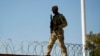 FILE - A guardsman walks over rail cars with concertina wire along the US-Mexico border, Jan. 3, 2024, in Eagle Pass, Texas. 