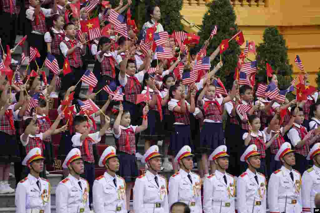 កុមារាកុមារីបក់ទង់ជាតិវៀតណាមនិងអាមេរិកដើម្បីទទួលស្វាគមន៍ប្រធានាធិបតីសហរដ្ឋអាមេរិកលោក Joe Biden ក្នុងរដ្ឋធានីហាណូយប្រទេសវៀតណាមកាលពីថ្ងៃទី១០ កញ្ញា ឆ្នាំ២០២៣។(AP Photo/Evan Vucci)