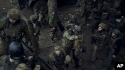 烏克蘭軍人在巴赫穆特前線休息時相互擁抱。（2023年5月27日）