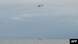 This photo shows a Philippine Coast Guard helicopter flying about two kilometres off the coast of Malolos municipality, Bulacan province on July 29, 2024. A tanker carrying 1.4 million liters of industrial fuel oil sank in bad weather off Manila Bay on early Thursday.