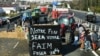 Farmers block A63 highway to protest over taxation and declining income, near Bayonne, on Jan. 23, 2024. The sign says "Our end will be your hunger." 