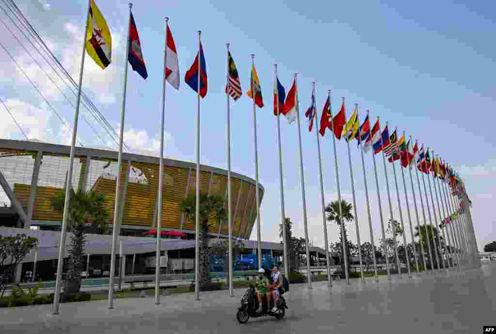 ពលរដ្ឋជិះម៉ូតូកាត់ទង់ជាតិនៅមុខពហុកីឡដ្ឋានជាតិមរតកតេជោ មុនការប្រកួតកីឡាស៊ីហ្គេមលើកទី ៣២ នៅរាជធានីភ្នំពេញ ថ្ងៃទី ៣ ខែឧសភា ឆ្នាំ ២០២៣។
