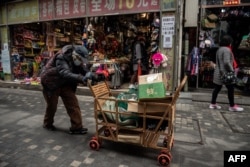 資料照：一名拾荒老人走過北京街頭。 （2021年3月5日）