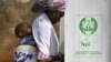 Une mère avec son bébé se prépare à voter dans un bureau de vote à Yola, dans l'État d'Adamawa, le 25 février 2023, lors des élections présidentielles et générales au Nigeria.