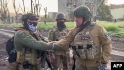 瓦格納集團僱傭軍首領普里戈津（右）在巴赫穆特與僱傭軍士兵在一起。（2023年5月25日）