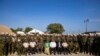 Waziri mkuu wa Haiti Garry Conille, akipiga picha na maafisa wa polisi wa Kenya kwenye kambi yao mjini Port-au Prince, Juni 26, 2024. Picha ya AP