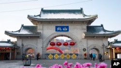 FILE - Tourists walk past a gateway with the name "Beishan" seen at the Beishan Park in northeastern China's Jilin province, Jan. 23, 2020. Four instructors from Iowa's Cornell College who were teaching at Beihua University were attacked, reportedly with a knife, June 10, 2024.