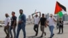 People waving Palestinian flags walk toward the Imam Muhammad bin Abdul Wahhab mosque in Doha, Qatar, on Aug. 2, 2024, for the funeral of Hamas leader Ismail Haniyeh.