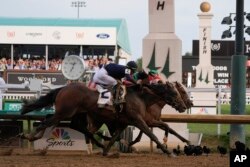 Sierra Leone with jockey Tyler Gaffalione (2), Forever Young with jockey Ryusei Sakai and Mystik Dan with jockey Brian Hernandez Jr., cross the finish line at Churchill Downs during the 150th Kentucky Derby horse race in Louisville, Kentucky, May 4, 2024.
