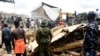 People gather at the scene of a collapsed two-story building in Jos, Nigeria, July, 12, 2024.