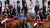 France's Prime Minister Gabriel Attal, President Emmanuel Macron and first lady Brigitte Macron applaud as the Cavalry Regiment of the French Republican Guard rides past during the Bastille Day military parade in Paris, July 14, 2024. 