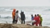 Des sauveteurs récupèrent un corps après le naufrage d'un bateau de migrants près de Cutro, dans le sud de l'Italie, dimanche 26 février 2023.