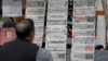 A man checks morning newspapers covering front page story of Iran's strike, at a stall in Islamabad, Jan. 18, 2024. 