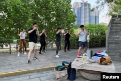資料照：北京街頭幾人在直播健身鍛煉。（2022年5月1日）