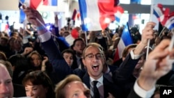 Des partisans du Rassemblement national, parti d'extrême droite français, réagissent au siège du parti lors de la soirée électorale, à Paris, le 9 juin 2024.