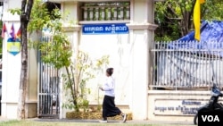 A student walks pass a sign "Thank You, Peace" in front of the Chatomuk Secondary School in Phnom Penh, on Monday, March 20, 2023. (Ten Soksreinith/VOA Khmer)