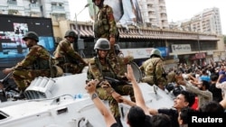 孟加拉國民眾在達卡街頭慶祝總理哈西娜辭職之際與孟加拉國軍人握手。（2024年8月5日）