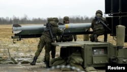 FILE - Spanish army servicemen prepare NASAMS medium range ground-based air defense rocket launcher, in Lielvarde air base, Latvia, March 29, 2023. 