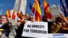 Protestors hold signs and wave Spanish flags during a demonstration called by the opposition party Partido Popular (PP) against the government's amnesty law, on the Plaza de Espana square in Madrid, Jan. 28, 2024.