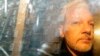 FILE - Buildings are reflected in the window as WikiLeaks founder Julian Assange is taken from court in London on May 1, 2019. Assange's possible final appeal on extradition to the United States will take place in Britain's High Court in February 2024.