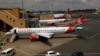 FILE - Kenya Airways planes are seen through a window at the Jomo Kenyatta international airport, in Nairobi, Kenya, Aug. 1, 2020.