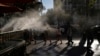 FILE - Pedestrians walk under cooling misters on a hot day in Las Vegas, Nevada, July 13, 2023. A recent study shows that intense and perpetual heat in the United States, Mexico and Central America is the result of human-caused climate change.  