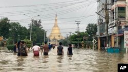 អ្នក​ស្រុក​ដើរ​កាត់​ផ្លូវ​លិច​ទឹក​ក្បែរ​វត្ត Shwe Maw Taw ក្នុង​ក្រុង Bago ចម្ងាយ​ប្រហែល​៨០ គីឡូម៉ែត្រ ភាគ​ឦសាន​ទីក្រុង​រ៉ង់ហ្គូន ប្រទេស​មីយ៉ាន់ម៉ា ថ្ងៃទី៩ ខែ​តុលា ឆ្នាំ២០២៣។