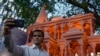 A person takes selfie in front of a replica of the Lord Ram temple in Ayodhya, which is on display outside India's ruling Bharatiya Janata Party office, in Mumbai, India, Jan. 16, 2024.
