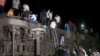 Para penumpang yang selamat mencoba keluar dari gerbong-gerbong kereta yang terguling menyusul tabrakan maut antara dua kereta penumpang di Balasore, India, Jumat, 2 Juni 2023. (Foto: ANI/Reuters TV via Reuters)
