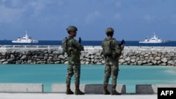 菲律賓士兵在南中國海有主權爭議的中業島上看著菲律賓海岸警衛隊的船隻。（2023年12月1日）