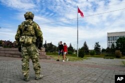 資料照：一名俄羅斯士兵在烏克蘭南部赫爾松地區的一處紀念廣場上站崗。 （2022年5月20日）