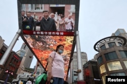 北京街頭的大屏幕電視報導中國領導人習近平在新疆參觀視察。（2022年7月15日）